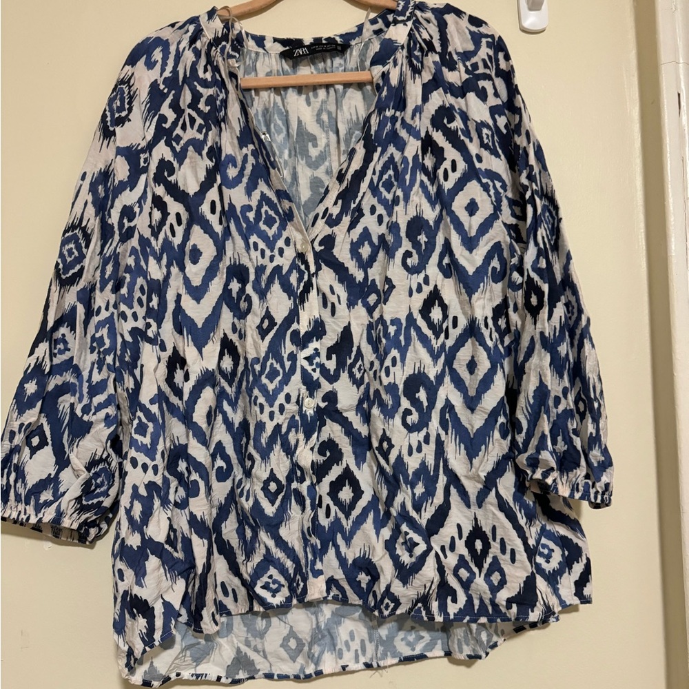Thin, blouse. Scrunched sleeves at the wrist. Half way button down.
